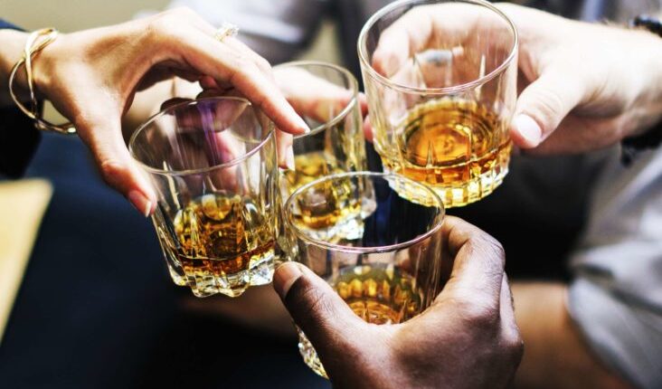 A group of people holding glass with alcohol